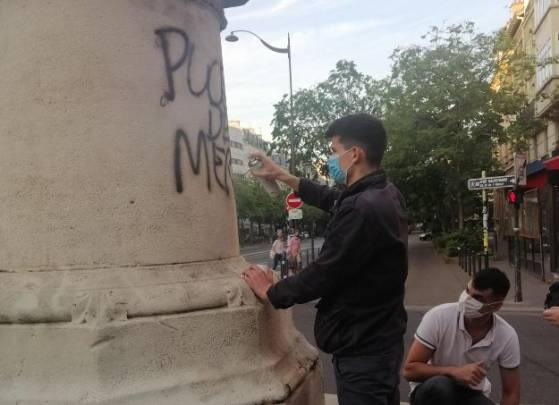 Des militants royalistes nettoient la statue de Jeanne d'Arc qui avait été recouverte de graffitis il y a quelques jours à Paris